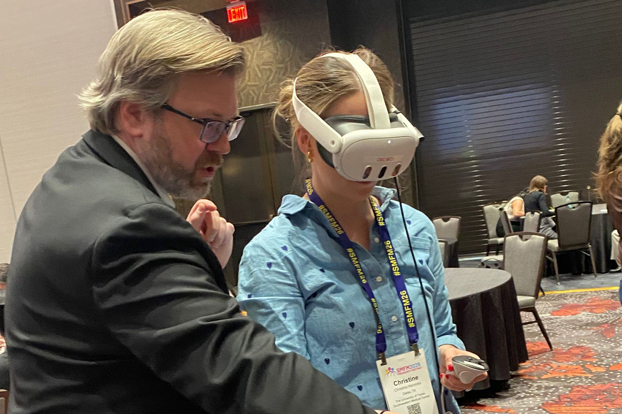 A bearded man talks to a woman wearing a VR headset