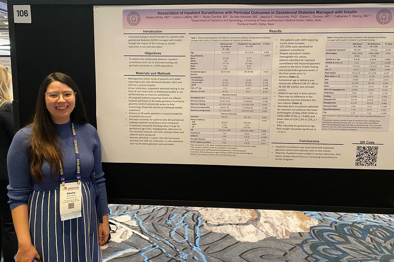 Dr. Alesha White in front of a conference poster