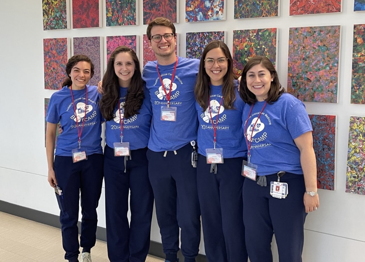 fellows standing in front of a wall of art