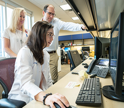 Dr. Moreland and Dr. Green with a fellow in the office on a Computer