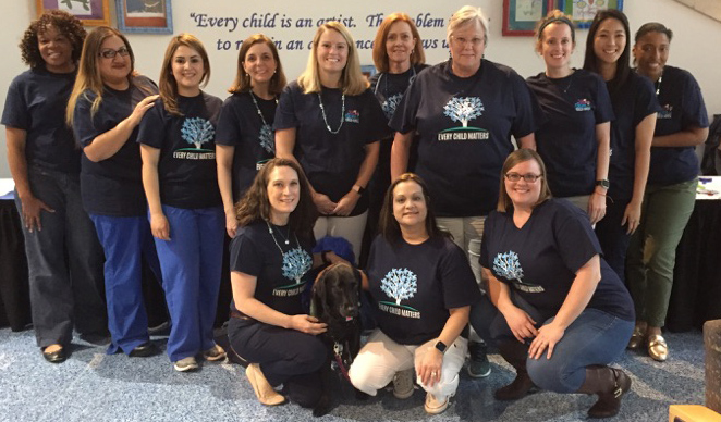 Group photo of seven women and a therapy dog