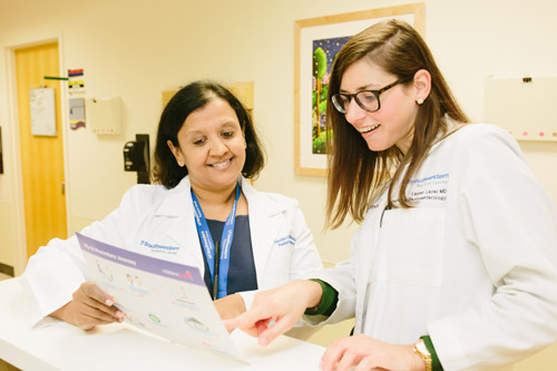 Two female doctors look at a chart