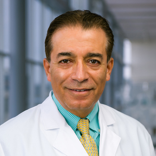 Dr. Aly, a smiling man with dark hair, wearing a dark suit