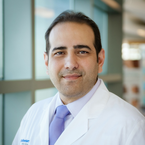 Dr. Amirlak, a smiling man with dark hair, wearing a lab coat.