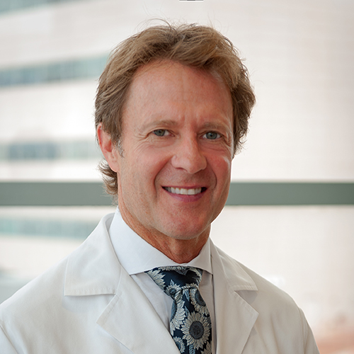 Dr. Kenkel, a smiling man with fair hair, wearing a lab coat.