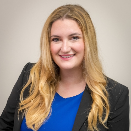 Anca Dogaroiu headshot, woman with long blonde hair in dark blazer and blue top