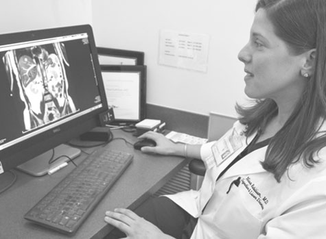 Woman in labcoat sitting at computer