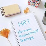 A notepad with the words 'HRT Hormone Replacement Therapy' written in blue