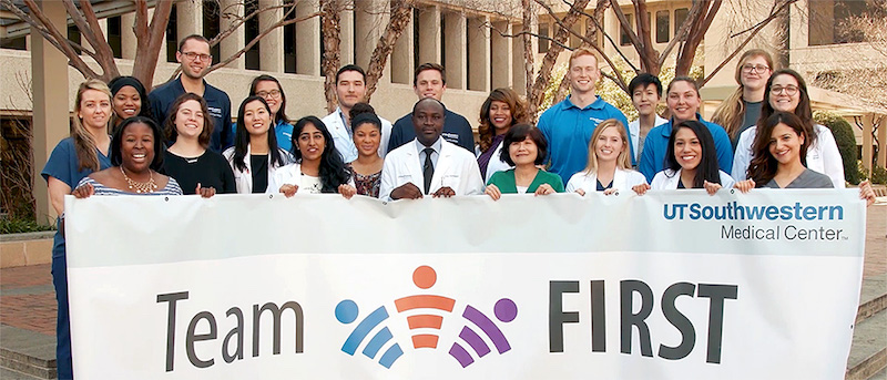 A group of students holding a Team FIRST banner