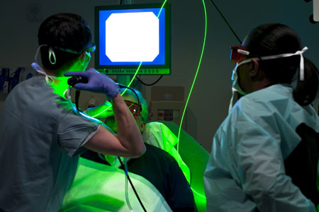 Two doctors with a green light on a patient