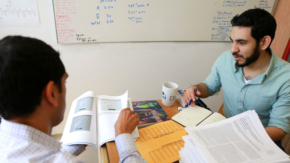 Two male students reviewing scholarly papers