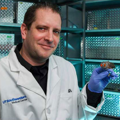 Dr. Todd Roberts with a songbird, Dr. Todd Roberts holds a songbird