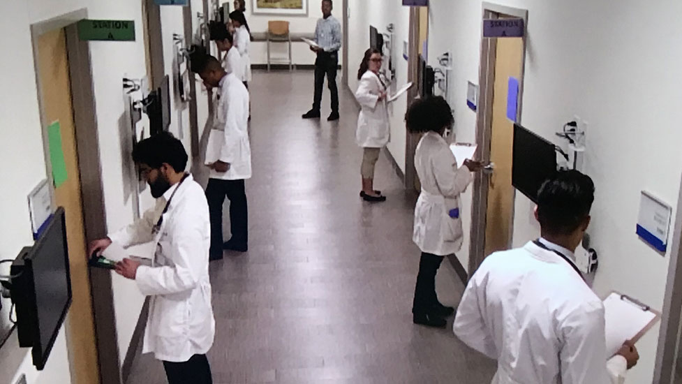 Students wait to enter the exam rooms in the Simulation Center