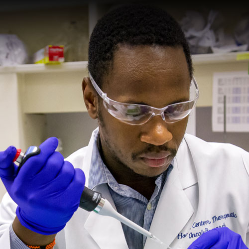 Man working in the lab holding a pipette