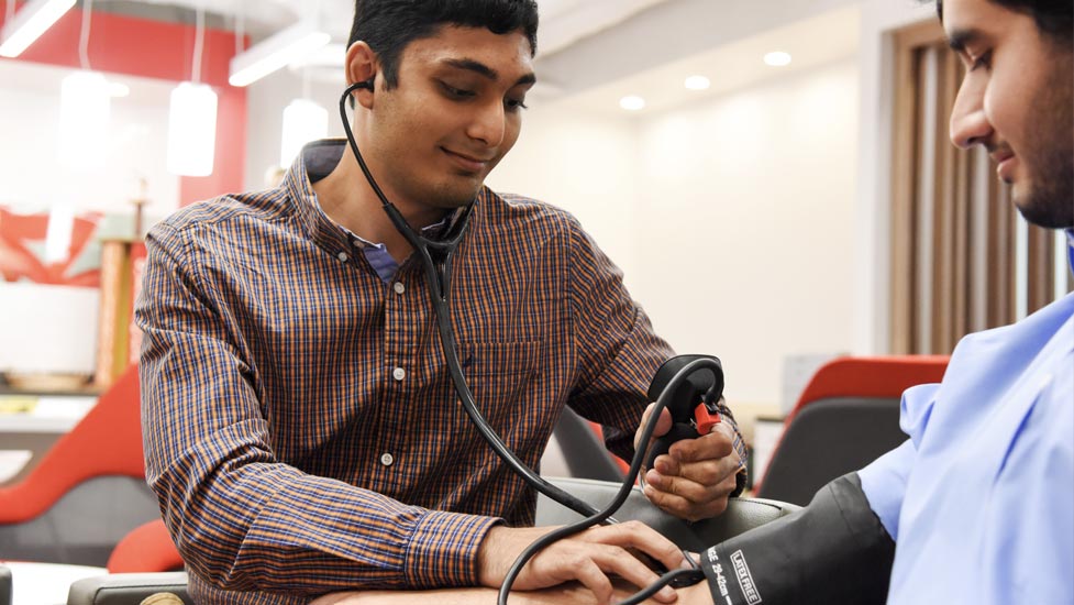 Student checks a person's blood pressure