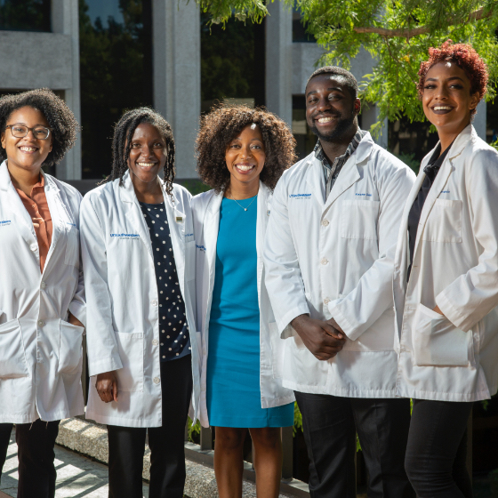 One male and four female medical students stand in a line