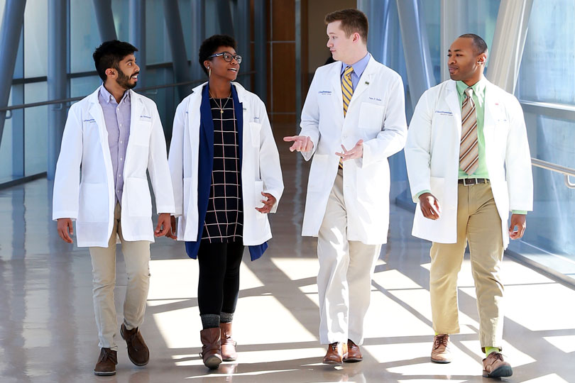 Medical student walk across a skybridge. Diverse medical student walking across a skybridge