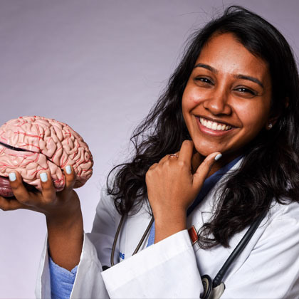 Yarlini Vipulanandan holding a model of a brain