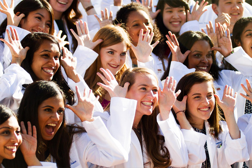 Female students make antlers with their hands to their heads
