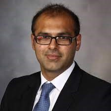 Man in black suit jacket and glasses