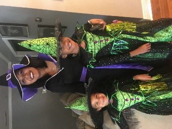 Woman and two children in colorful witch outfits