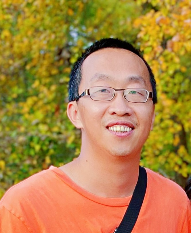 Man with short hair and an orange shirt