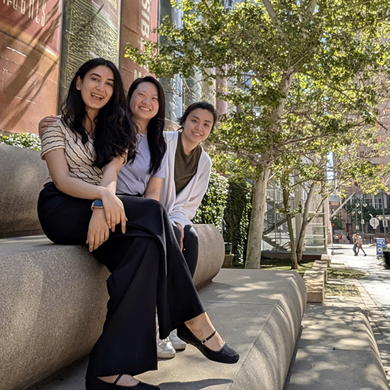 Three women sitting outside on some steps