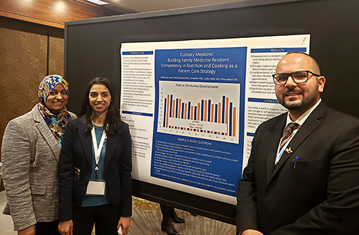 3 faculty with a research poster