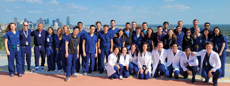 2021 Resident Class on top of Parkland hospital with city of Dallas in the background