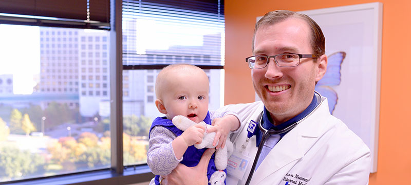 photo of Dr. Jason Newman with an infant patient
