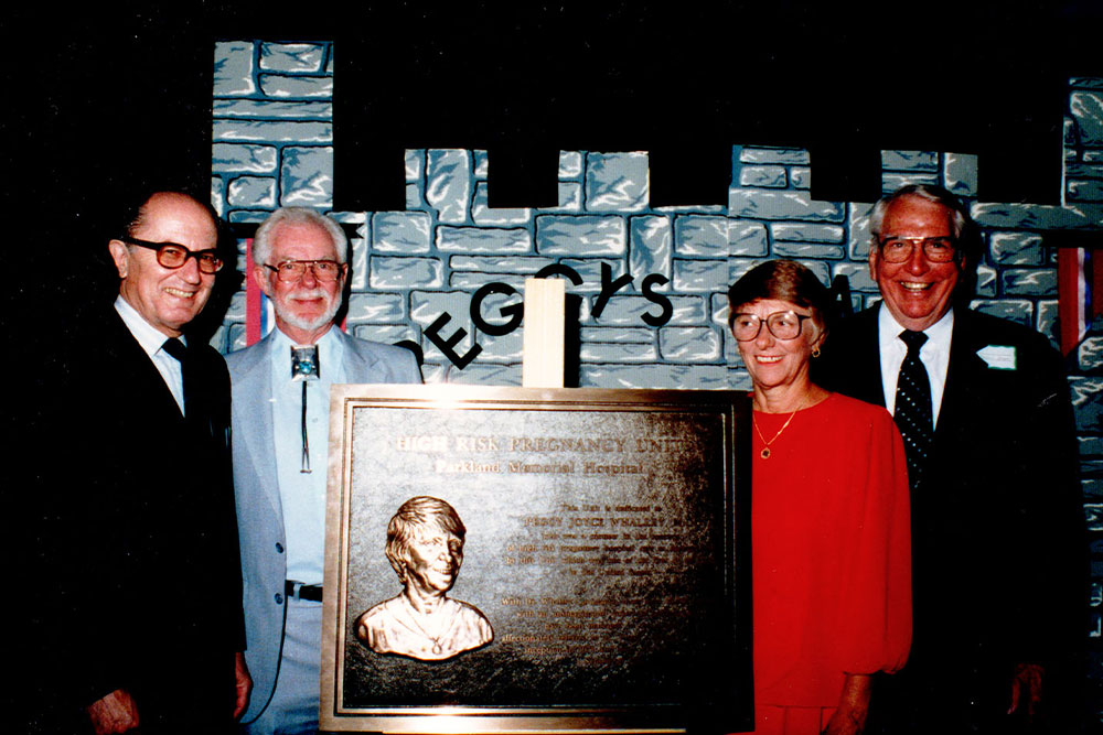 Dr. Whalley and three leaders of Ob/Gyn and UT Southwestern stand by a large plaque honoring Dr. Whalley on her retirement