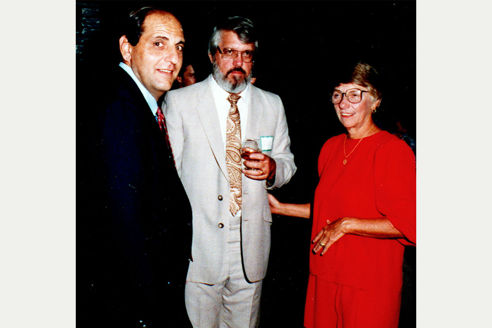 Dr. Whalley and two men gather at her retirement party