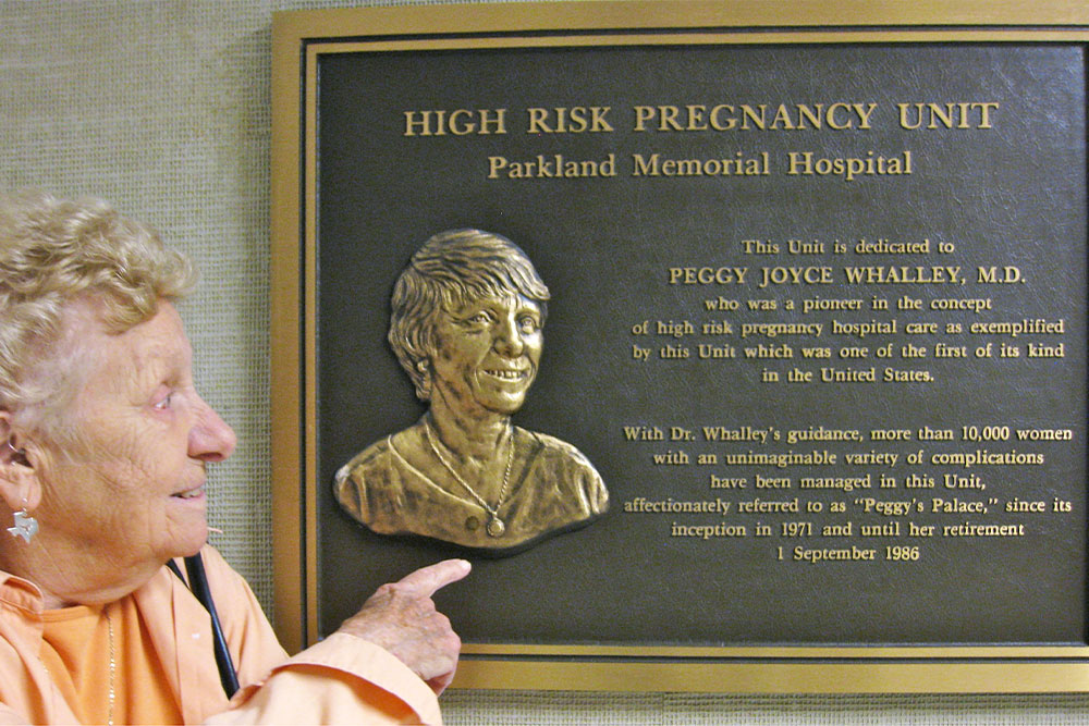 Dr. Whalley points to the plaque