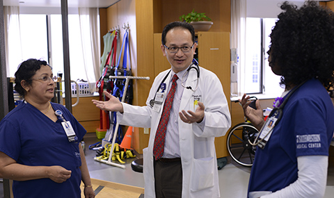 Dr. Benjamin Nguyen talking with two nurses.