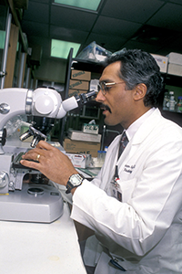 Orhan Oz looking through microscope