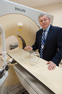 Robert Lenkinski standing by MRI machine