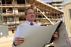Paul Warner holding blueprints in front of construction