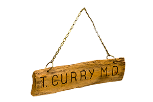 Rustic wooden sign saying T. Curry M.D.