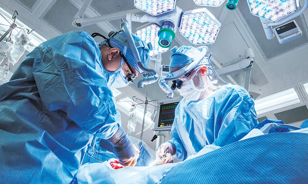 Two surgeons performing a liver transplant in an operating room