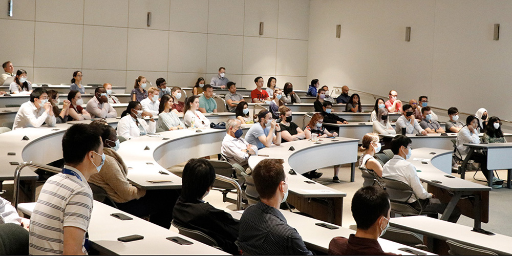 Audience seated in lecture hall listening to panel discussion