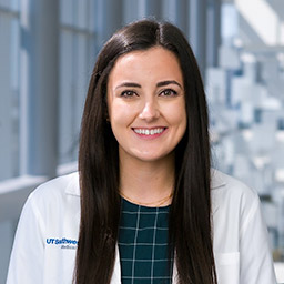 Woman with long dark hair in a white lab coat