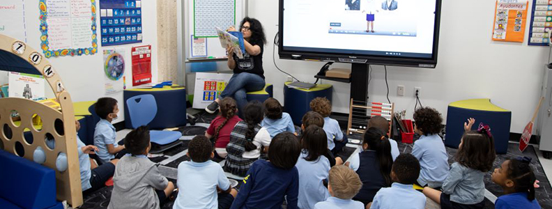 Female teacher reading to students in classroom