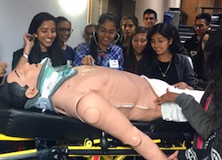 Students interact with a training mannequin.