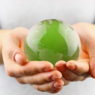hands holding a green sphere