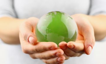 hands holding a green sphere