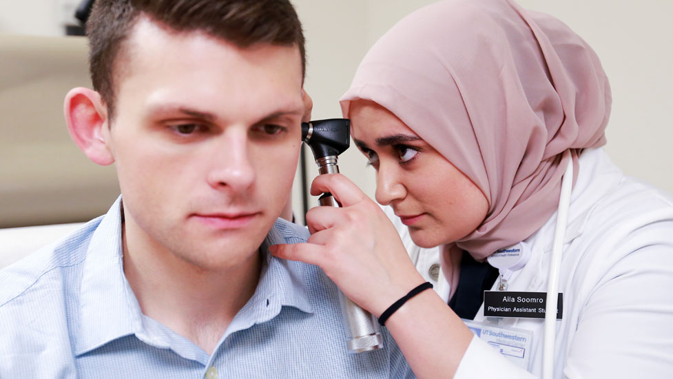 Student looking into a person's ear
