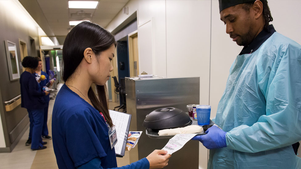 Nutrition student and a patient care technician looking over a patient's dinner order