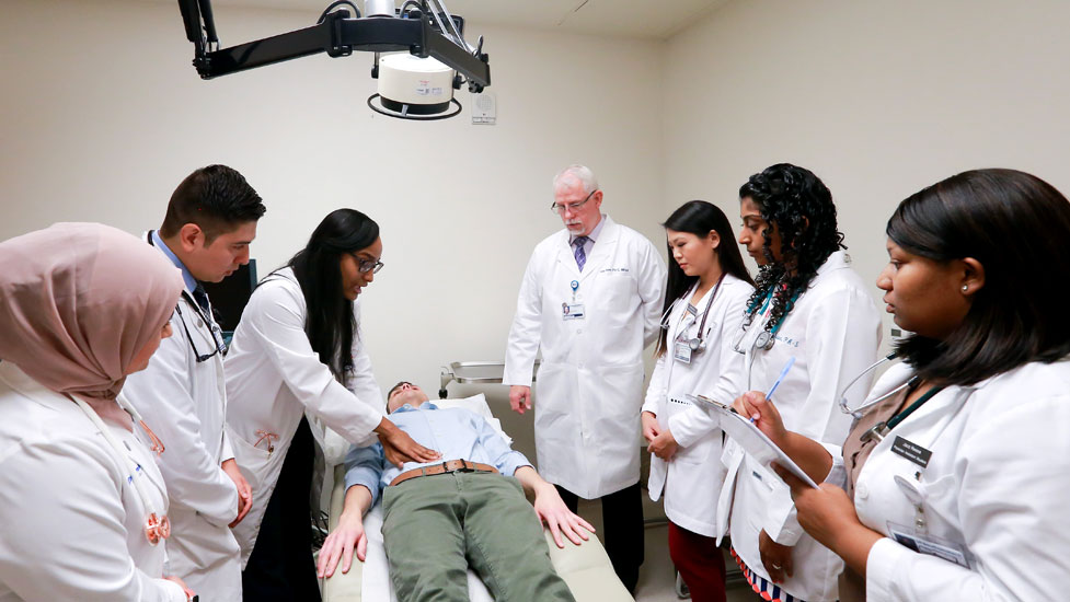 Faculty with students demonstrating a physician exam