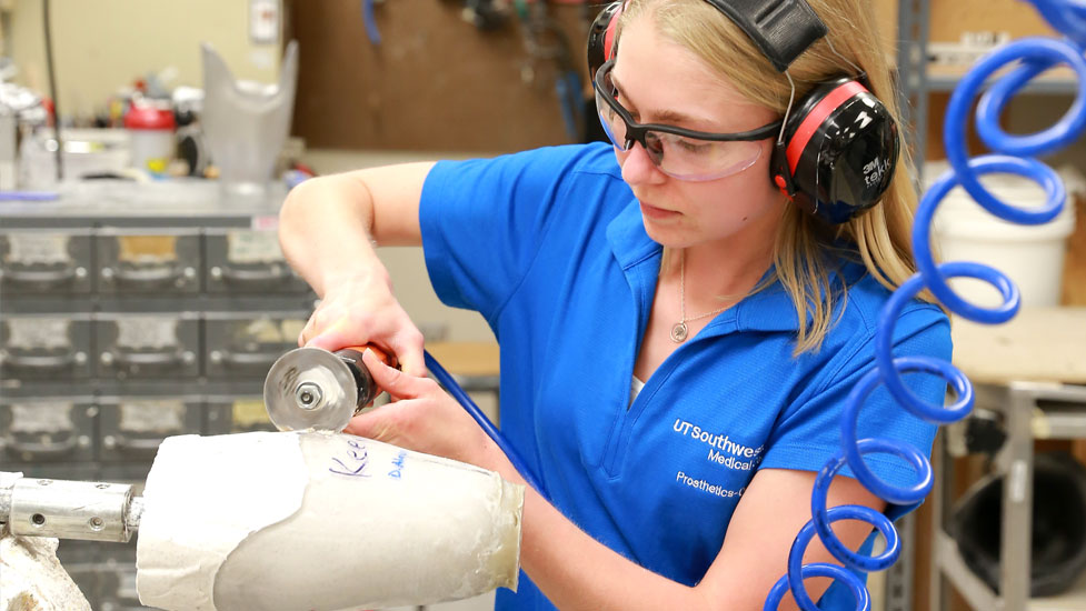 Student cutting open a cast