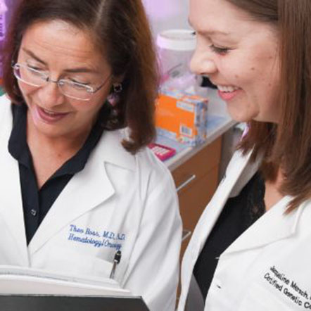 Female physician and genetic counselor scanning through a textbook